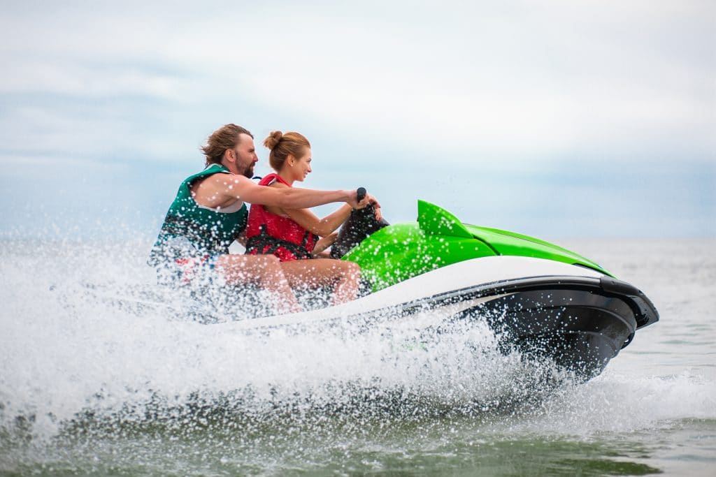 young people having fun driving high speed water scooter man woman summer vacation friends doing active sport 2